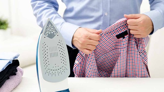 man ironing his new shirt